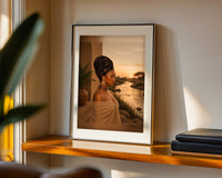 At The River golden-hour portrait print framed on a wooden shelf, close-up view