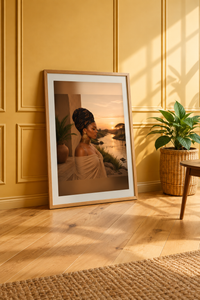 At The River sunset portrait print in a wood frame leaning against a warm yellow paneled wall